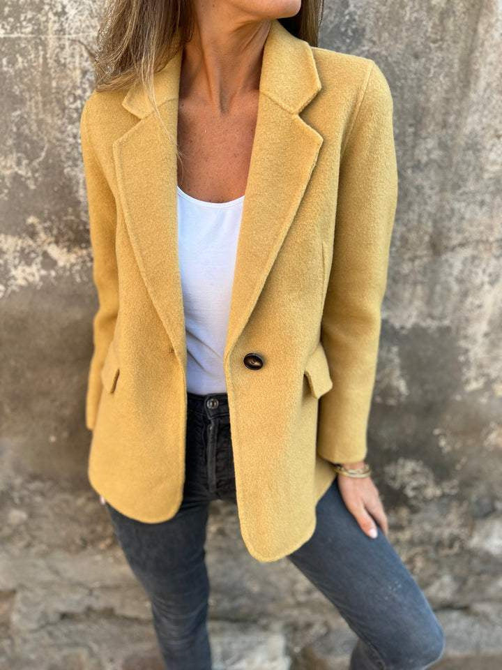 Classic lapel suit jacket worn by a woman, showcasing timeless fashion with a brown design and casual styling.