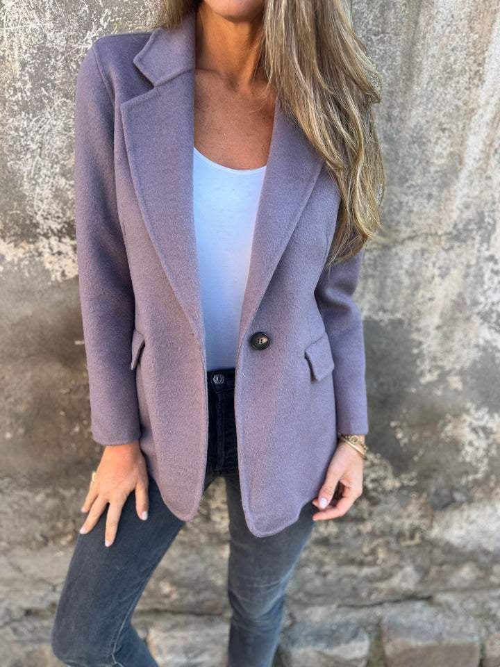 Classic lapel suit jacket worn by a woman, showcasing timeless fashion with a deep harse design and casual styling.